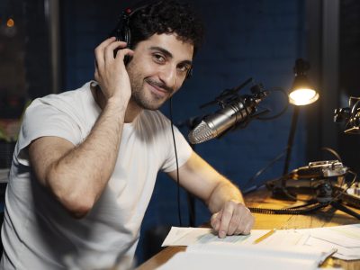 hombre-con-microfono-y-auriculares-ejecutando-un-podcast-en-el-estudio